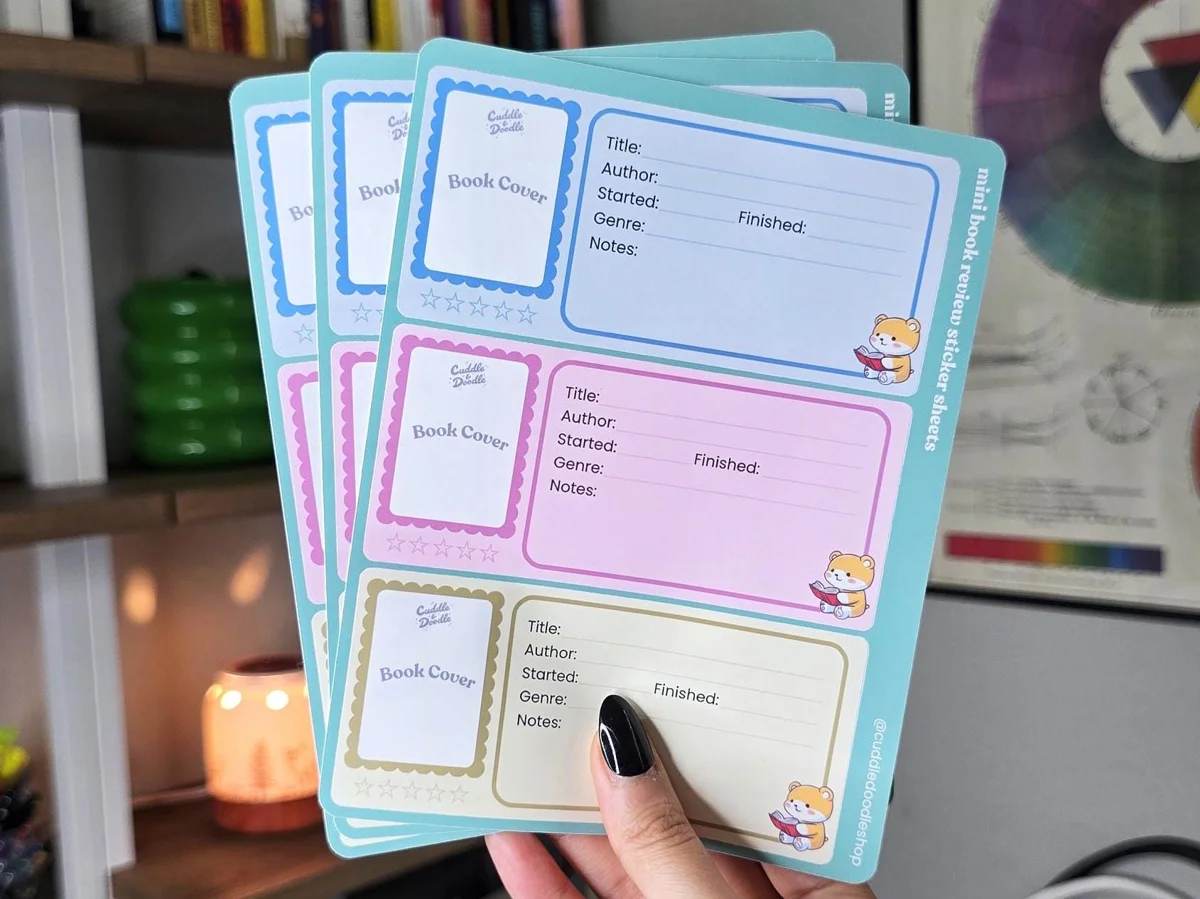 Mini book review sticker sheets held in a hand, showing their real-world size